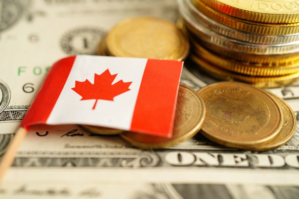 Canada flag on stack of coin money, finance banking business.
